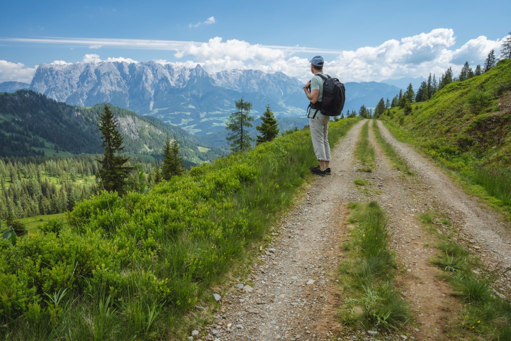 Reisende mann på tursti og nyter Wilder Kaiser-fjellene, Tirol - Østerrike
