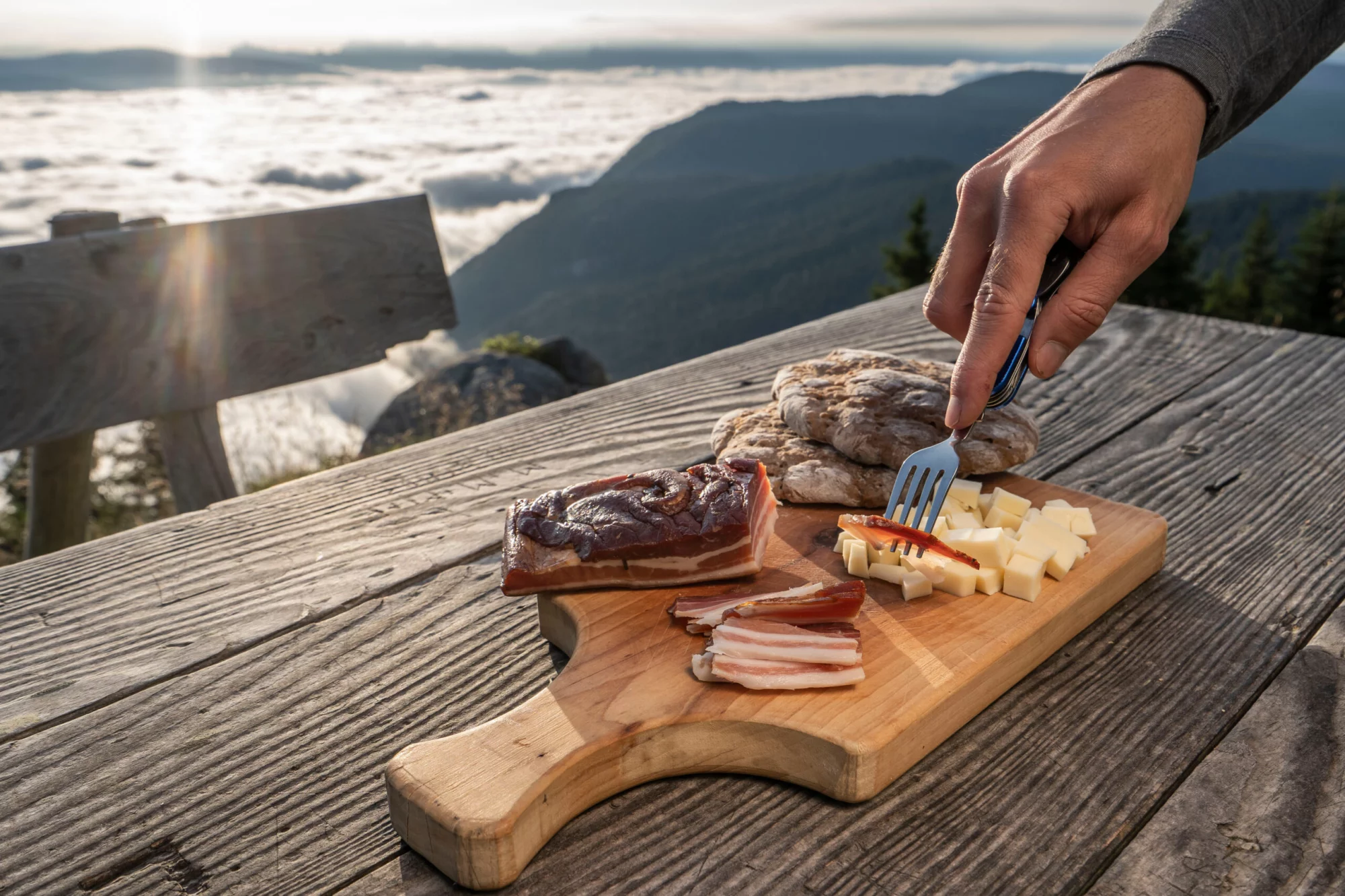 Snack with delicious South Tyrolean smoked bacon and cheese with flat bread lying on a rustic table